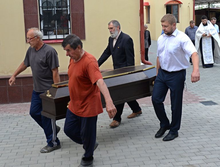 Люди выносят гроб с телом прихожанина Артемия, погибшего при нападении на храм Архангела Михаила в Грозном. 22 мая 2018
