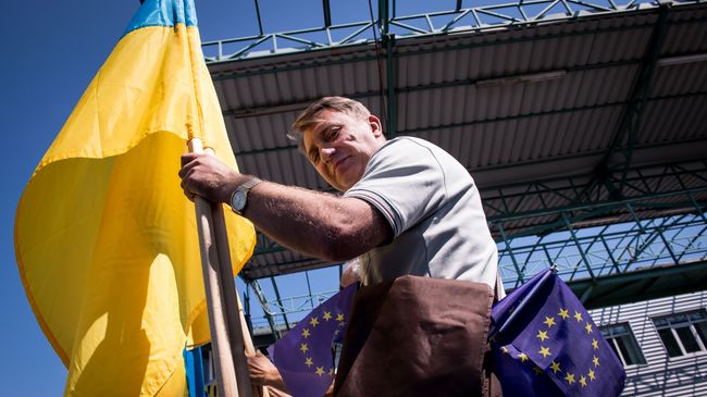 Мужчина с флагами Украины и Евросоюза на границе Словакии и Украины. Архивное фото Мужчина с флагами Украины и Евросоюза на границе Словакии и Украины. Архивное фото