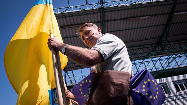 Мужчина с флагами Украины и Евросоюза. Архивное фото Мужчина с флагами Украины и Евросоюза. Архивное фото