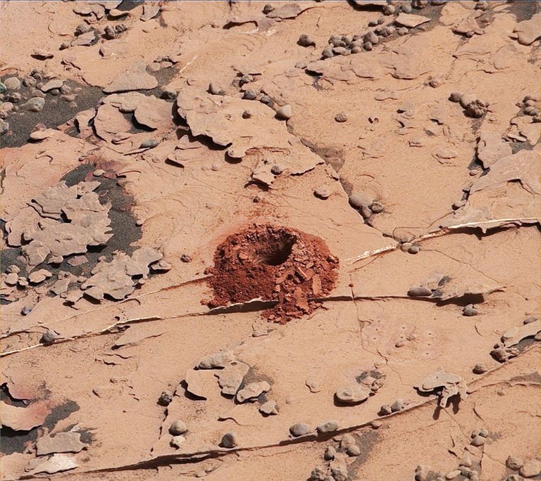 Первая лунка, вырытая починенным буром Curiosity в камне Дулут Первая лунка, вырытая починенным буром Curiosity в камне Дулут