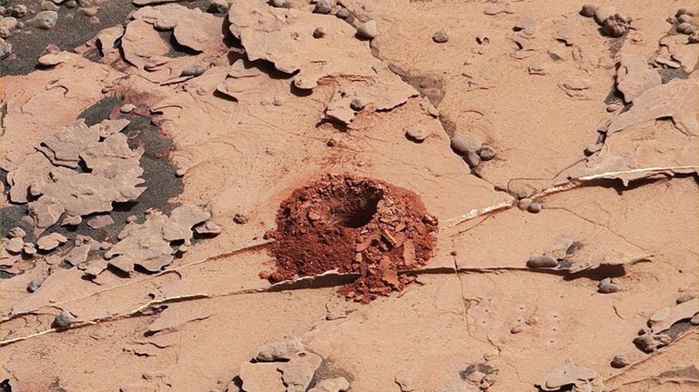 Первая лунка, вырытая починенным буром Curiosity в камне Дулут Первая лунка, вырытая починенным буром Curiosity в камне Дулут