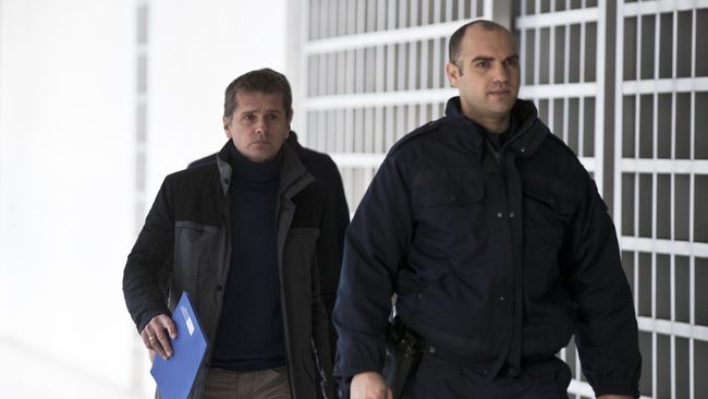 Полицейский сопровождает Александра Винника в Верховный суд Греции в Афинах. Архивное фото