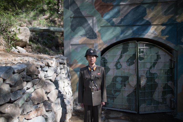 Военнослужащий у входа в шахту для ядерных испытаний №2 на ядерном полигоне Пхунгери на севере КНДР Военнослужащий у входа в шахту для ядерных испытаний №2 на ядерном полигоне Пхунгери на севере КНДР