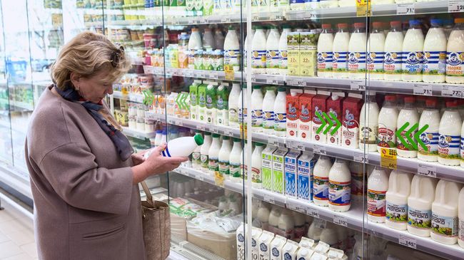 Покупатель у витрины с молочной продукцией Покупатель у витрины с молочной продукцией