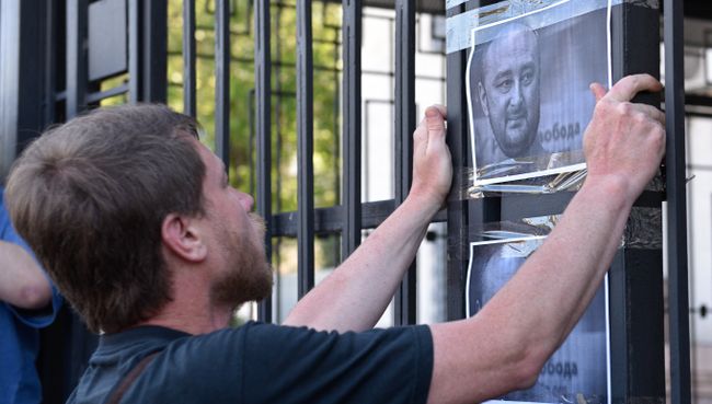 Мужчина клеит листовки с портретом убитого российского журналиста Аркадия Бабченко у здания посольства РФ в Киеве. 30 мая 2018 Мужчина клеит листовки с портретом убитого российского журналиста Аркадия Бабченко у здания посольства РФ в Киеве. 30 мая 2018