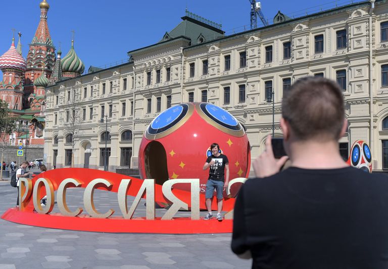 Молодые люди фотографируются рядом с символикой, посвященной предстоящему чемпионату мира по футболу 2018 в Москве