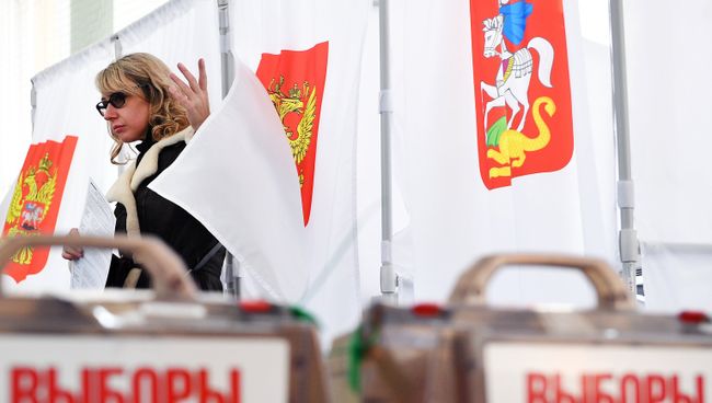 Девушка во время голосования на выборах президента РФ на избирательном участке №13-06 в Москве
