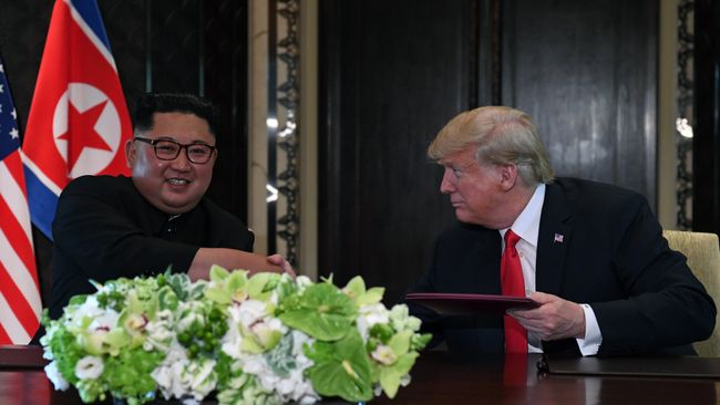 Лидер КНДР Ким Чен Ын и президент США Дональд Трамп во время церемонии подписания документов по итогам встречи в Сингапуре. 12 июня 2018