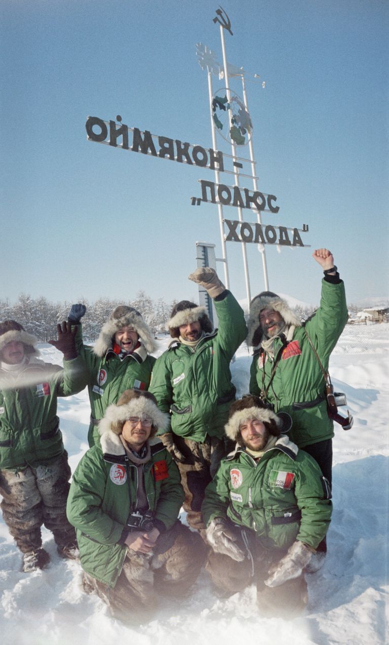 Туристы стоят у памятного знака Оймякон - полюс холода Туристы стоят у памятного знака Оймякон - полюс холода