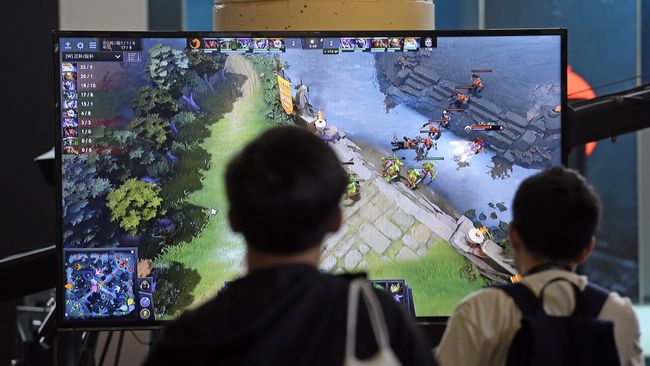 Подростки следят за игрой команд в Dota 2 Подростки следят за игрой команд в Dota 2
