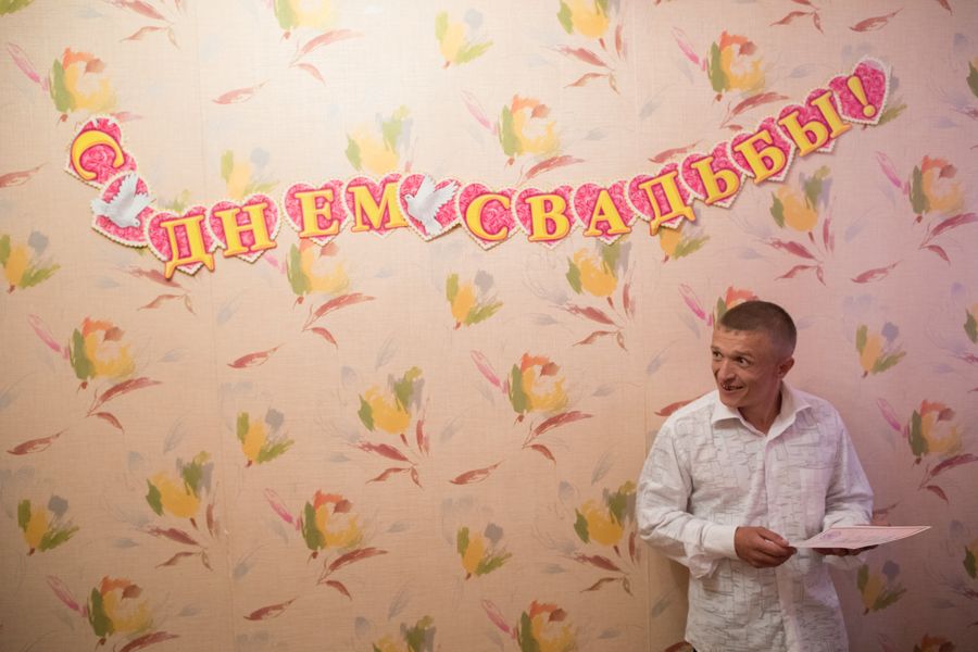 Мужчина держит в руках свежеподписанное свидетельство о заключении брака 