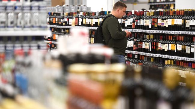 Покупатель в отделе алкогольной продукции. Архивное фото Покупатель в отделе алкогольной продукции. Архивное фото