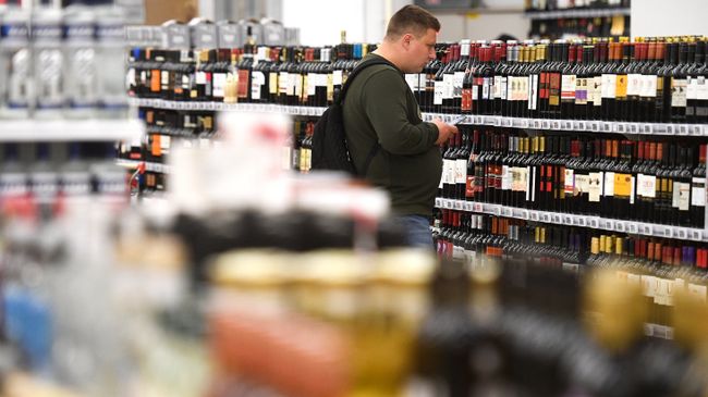 Покупатель в отделе алкогольной продукции. Архивное фото Покупатель в отделе алкогольной продукции. Архивное фото