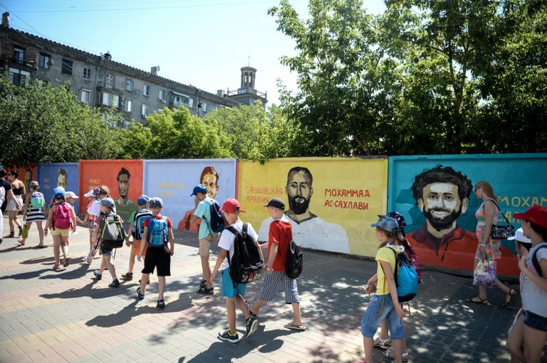 Дети на фоне граффити-портретов футболистов восьми сборных на бетонном заборе на пересечении улиц Советской и Комсомольской в Волгограде в рамках проведения чемпионата мира по футболу 2018 Дети на фоне граффити-портретов футболистов восьми сборных на бетонном заборе на пересечении улиц Советской и Комсомольской в Волгограде в рамках проведения чемпионата мира по футболу 2018