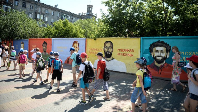 Дети на фоне граффити-портретов футболистов восьми сборных на бетонном заборе на пересечении улиц Советской и Комсомольской в Волгограде в рамках проведения чемпионата мира по футболу 2018