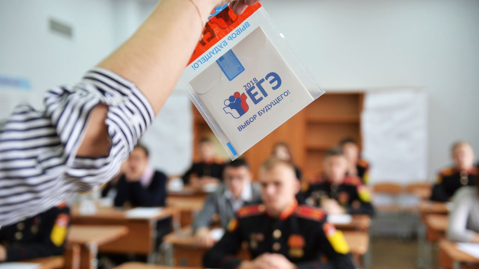 Преподаватель демонстрирует пакет и компакт-диск с заданиями перед началом ЕГЭ по математике в Екатеринбурге - РИА Новости, 1920, 31.05.2021