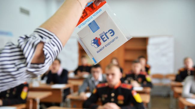 Преподаватель демонстрирует пакет и компакт-диск с заданиями перед началом единого государственного экзамена по базовой математике в Лицее №88 в Екатеринбурге. Архивное фото