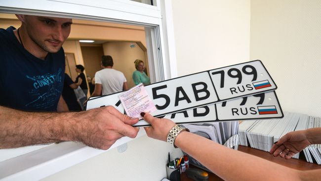 Выдача автовладельцу номерных знаков в одном из отделов регистрации транспортных средств. Архивное фото Выдача автовладельцу номерных знаков в одном из отделов регистрации транспортных средств. Архивное фото