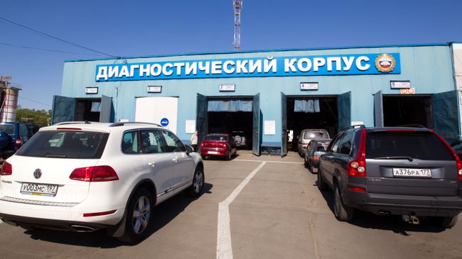 Легковые автомашины въезжают в диагностический корпус пункта государственного технического осмотра автомобилей 