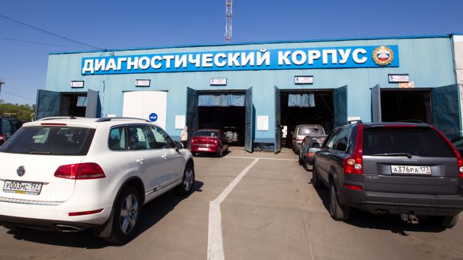 Легковые автомашины въезжают в диагностический корпус пункта государственного технического осмотра автомобилей Легковые автомашины въезжают в диагностический корпус пункта государственного технического осмотра автомобилей