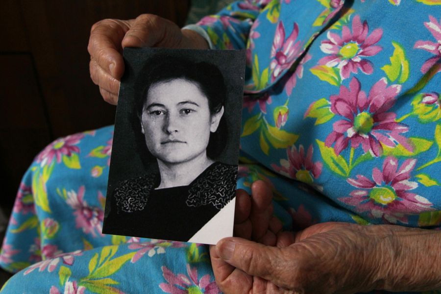 Раиса Александровна Шувар держит свою фотографию послевоенного времени