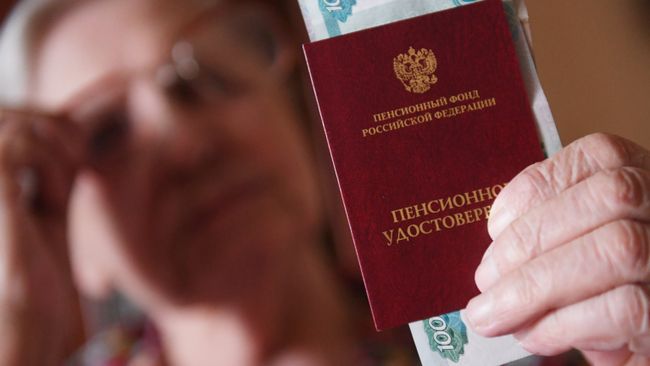 Женщина держит пенсионное удостоверение Женщина держит пенсионное удостоверение