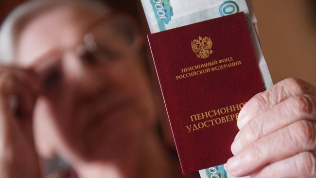 Женщина держит пенсионное удостоверение. Архивное фото Женщина держит пенсионное удостоверение. Архивное фото