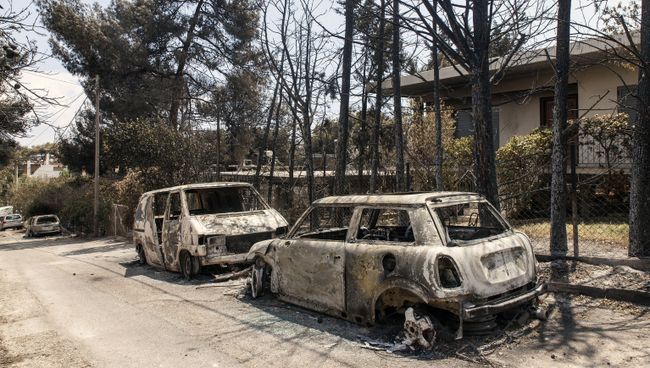 Сгоревшие в результате лесных пожаров автомобили на улице Мати в Греции. 25 июля 2018