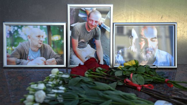 Цветы у фотографий погибших в Центральноафриканской Республике  журналистов: Орхана Джемаля, Кирилла Радченко и Александра Расторгуева возле Дома журналистов в Москве. 1 августа 2018