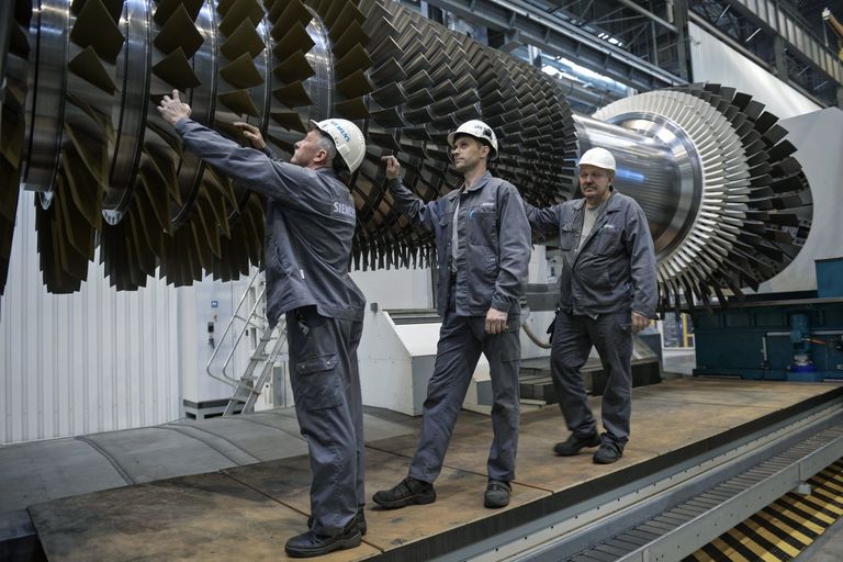 Рабочие ООО Сименс технологии газовых турбин осматривают ротор с лопатками в цехе по восстановлению лопаток газовых турбин Рабочие ООО Сименс технологии газовых турбин осматривают ротор с лопатками в цехе по восстановлению лопаток газовых турбин