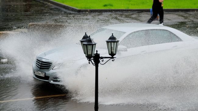 Автомобиль едет по улице во время дождя. Архивное фото