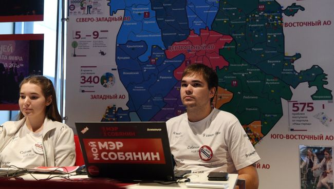 Волонтеры и посетитель в предвыборном штабе Сергея Собянина