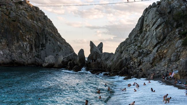Отдыхающие на пляже курортного поселка Симеиз в Крыму Отдыхающие на пляже курортного поселка Симеиз в Крыму