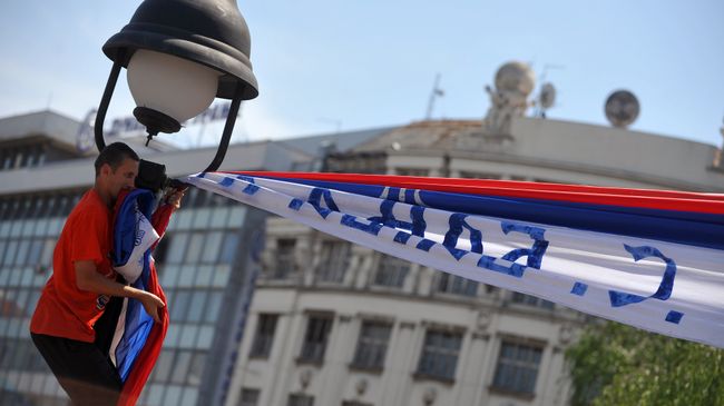 Демонстрант во время протеста против соглашения о нормализации отношений между Сербией и Косово в Белграде Демонстрант во время протеста против соглашения о нормализации отношений между Сербией и Косово в Белграде