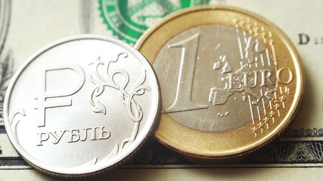 Монеты номиналом один рубль, один евро на банкноте один доллар США Монеты номиналом один рубль, один евро на банкноте один доллар США