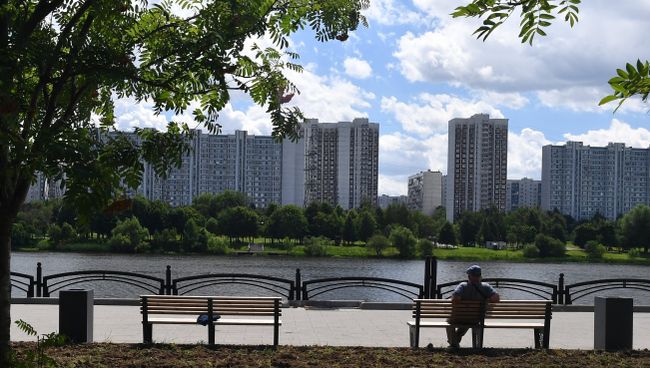 Мужчина сидит на лавочке на набережной Москвы-реки на территории парка 850-летия Москвы в районе Марьино Мужчина сидит на лавочке на набережной Москвы-реки на территории парка 850-летия Москвы в районе Марьино