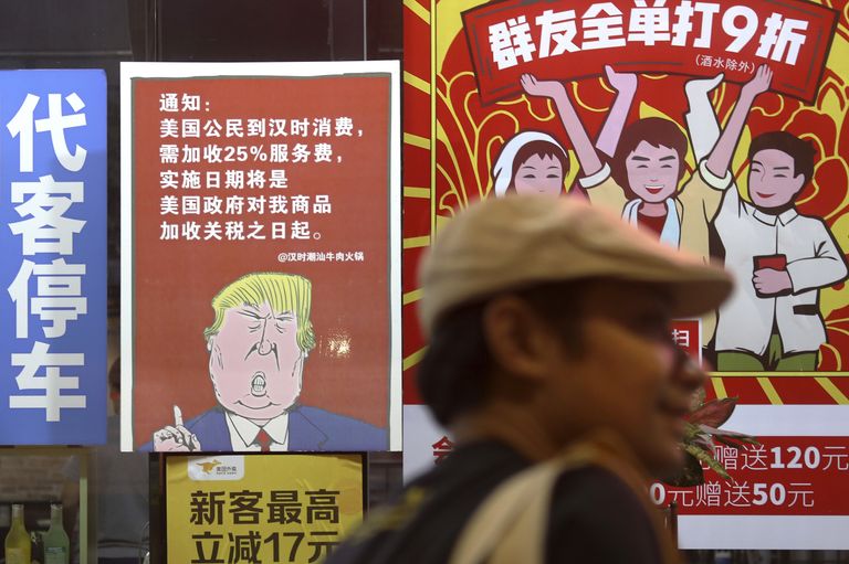 Плакат с изображением президента США Дональда Трампа и сообщением о введении 25% торговых пошлин на товары из Китая в Гуанчжоу Плакат с изображением президента США Дональда Трампа и сообщением о введении 25% торговых пошлин на товары из Китая в Гуанчжоу