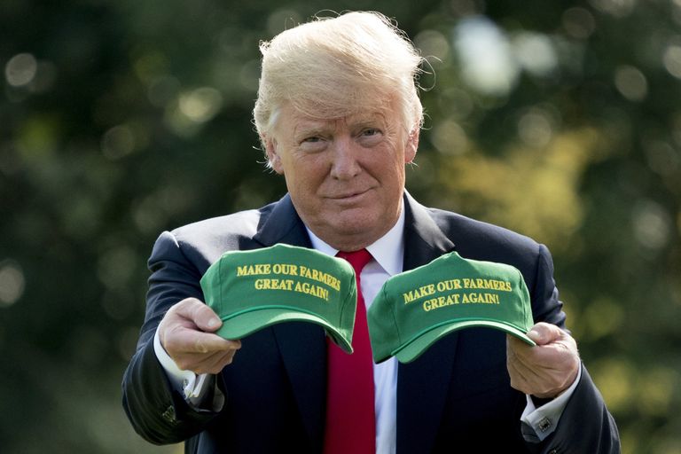 Президент США Дональд Трамп демонстрирует кепки с надписью Сделаем наших фермеров снова великими. Вашингтон, США 