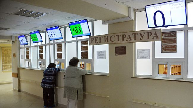 Посетители у регистратуры городской больницы Посетители у регистратуры городской больницы