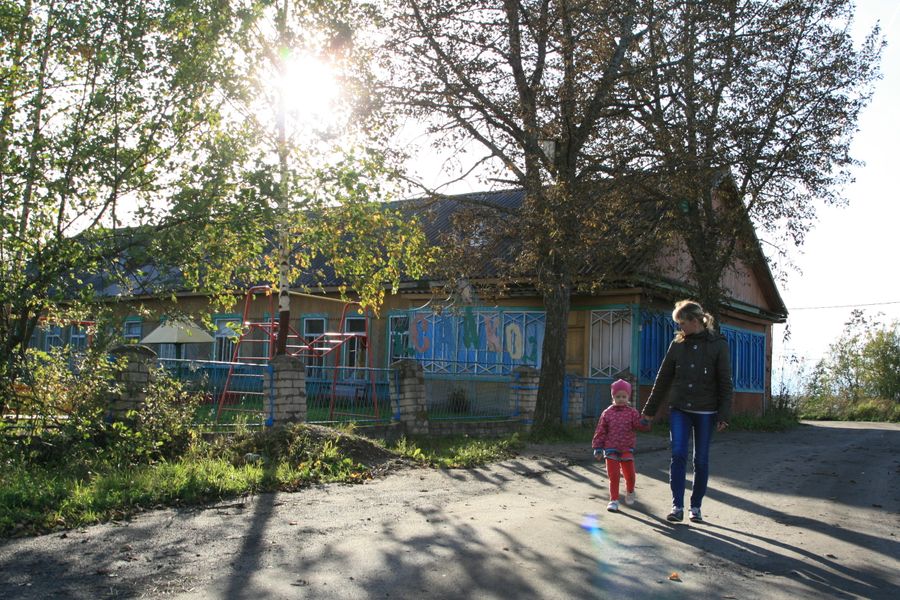 Местная жительница забирает дочь из детского сада. Раньше его отапливала колония Местная жительница забирает дочь из детского сада. Раньше его отапливала колония