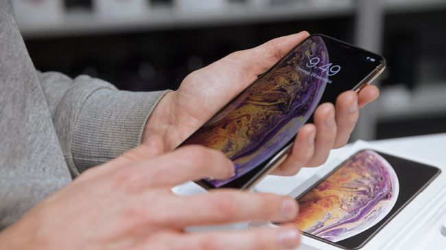 Посетитель рассматривает телефон iPhone XS Max