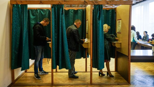 Избиратели голосуют на избирательном участке в Огре во время парламентских выборов в 13-й Сейм Латвии. 6 октября 2018 Избиратели голосуют на избирательном участке в Огре во время парламентских выборов в 13-й Сейм Латвии. 6 октября 2018