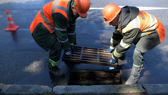 Сотрудники ЖКХ ведут работы по очистке от мусора ливневой канализации в Москве.