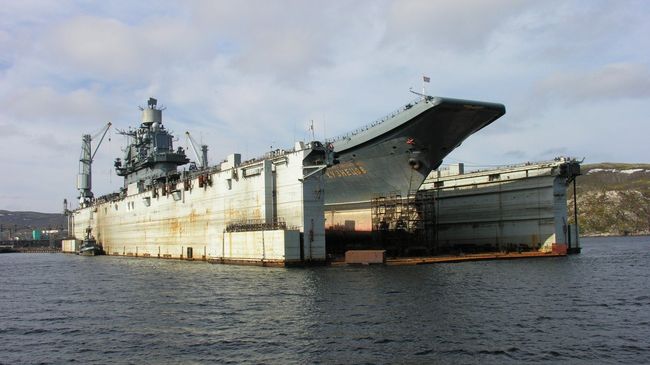 Тяжелый авианесущий крейсер Северного флота Адмирал Кузнецов в плавучем доке на 82-м судоремонтном заводе. Архивное фото Тяжелый авианесущий крейсер Северного флота Адмирал Кузнецов в плавучем доке на 82-м судоремонтном заводе. Архивное фото