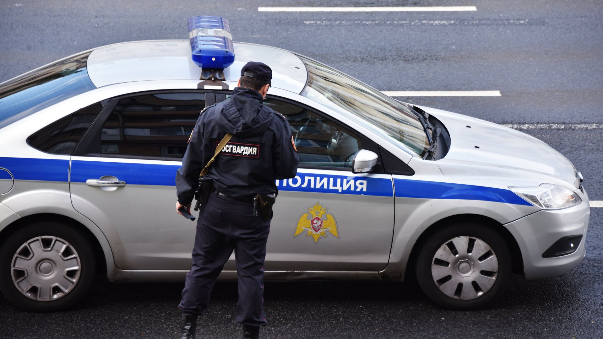 Сотрудник Росгвардии у полицейской машины Сотрудник Росгвардии у полицейской машины - РИА Новости, 1920, 17.03.2021