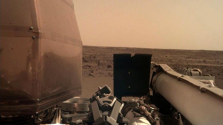 Первая фотография, полученная камерой руки зонда InSight после ее включения Первая фотография, полученная камерой руки зонда InSight после ее включения