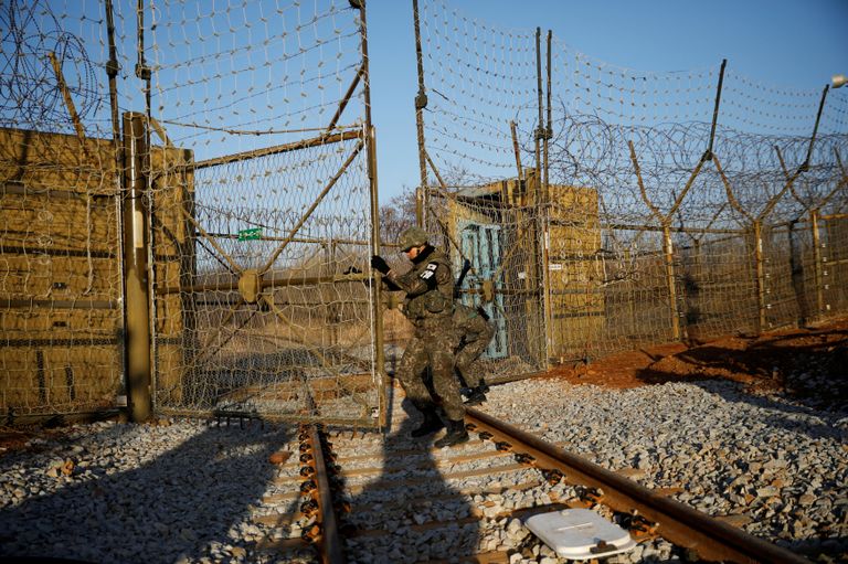 Южнокорейские солдаты открывают ворота железнодорожного пути в демилитаризованной зоне, разделяющей Северную и Южную Корею Южнокорейские солдаты открывают ворота железнодорожного пути в демилитаризованной зоне, разделяющей Северную и Южную Корею