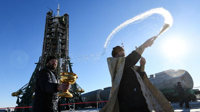 Священнослужитель проводит обряд освящения ракеты-носителя Союз-ФГ перед запуском на космодроме Байконур. 2 декабря 2018 Священнослужитель проводит обряд освящения ракеты-носителя Союз-ФГ перед запуском на космодроме Байконур. 2 декабря 2018