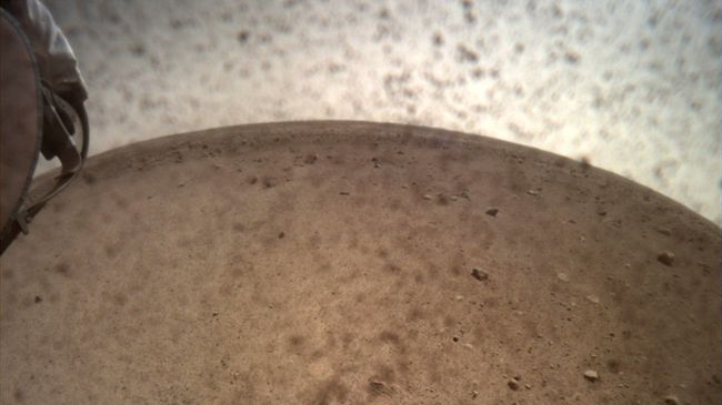 Первая фотография с главной камеры зонда InSight после снятия крышки Первая фотография с главной камеры зонда InSight после снятия крышки