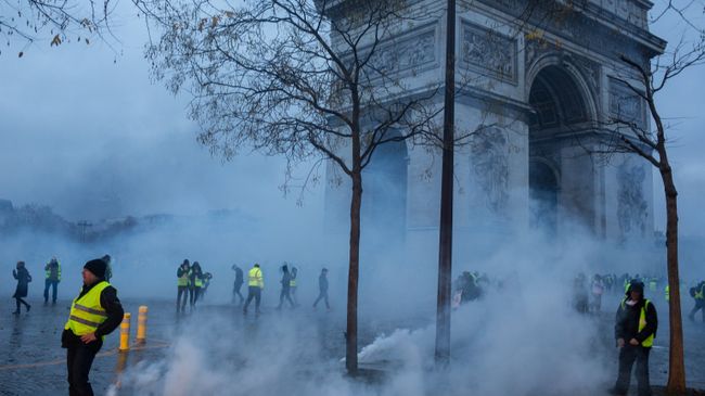 Участники протестной акции движения автомобилистов желтые жилеты, выступавшего с требованием снижения налогов на топливо, в районе Триумфальной арки в Париже. Архивное фото